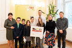 Gruppe von Kindern und Erwachsenen posiert mit einem Preis für globales Lernen.